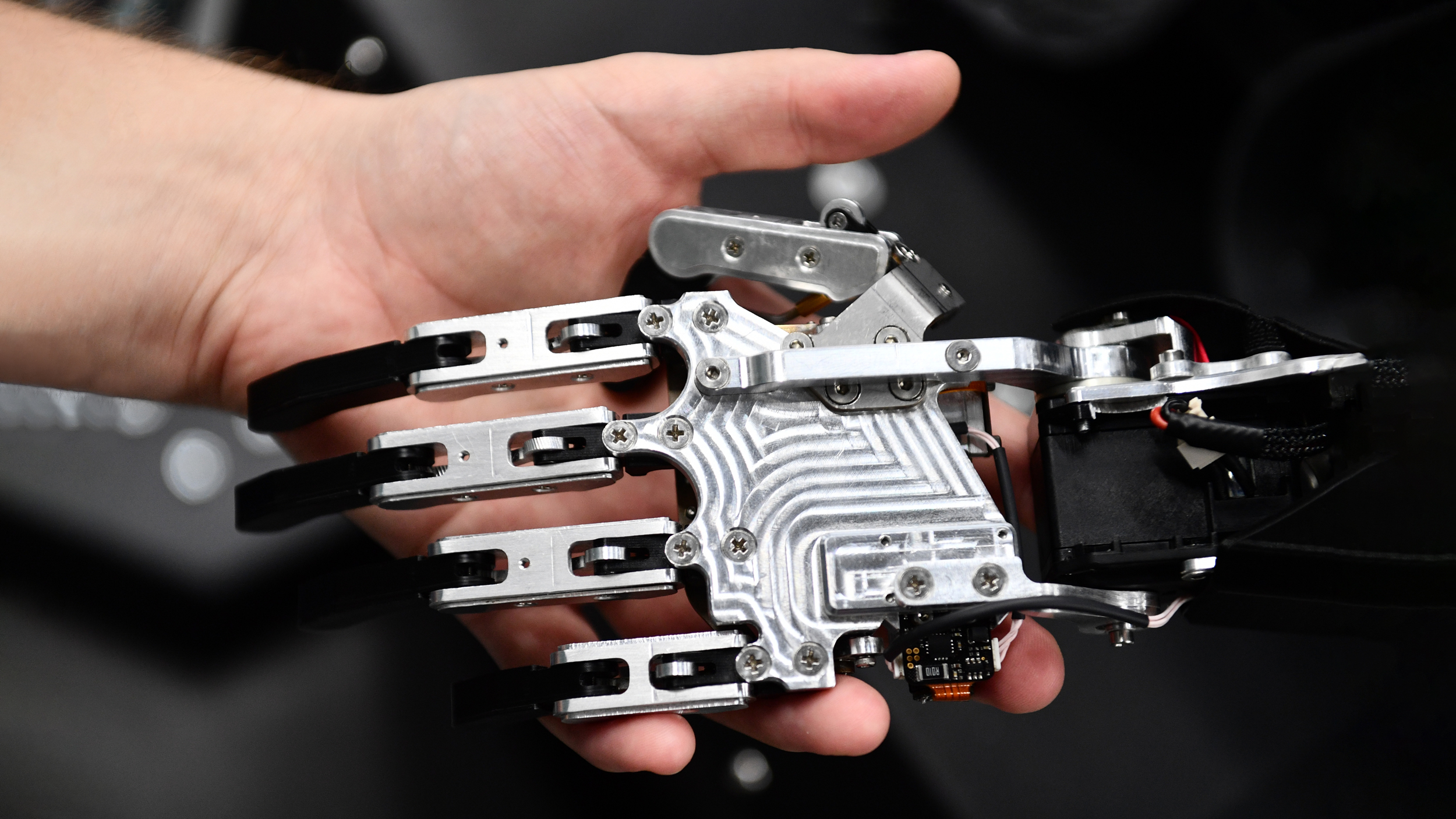 A man holds an arm of a humanoid robot